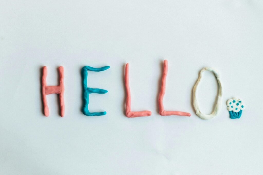 Hello written in colorful frosting punctuated with a cupcake